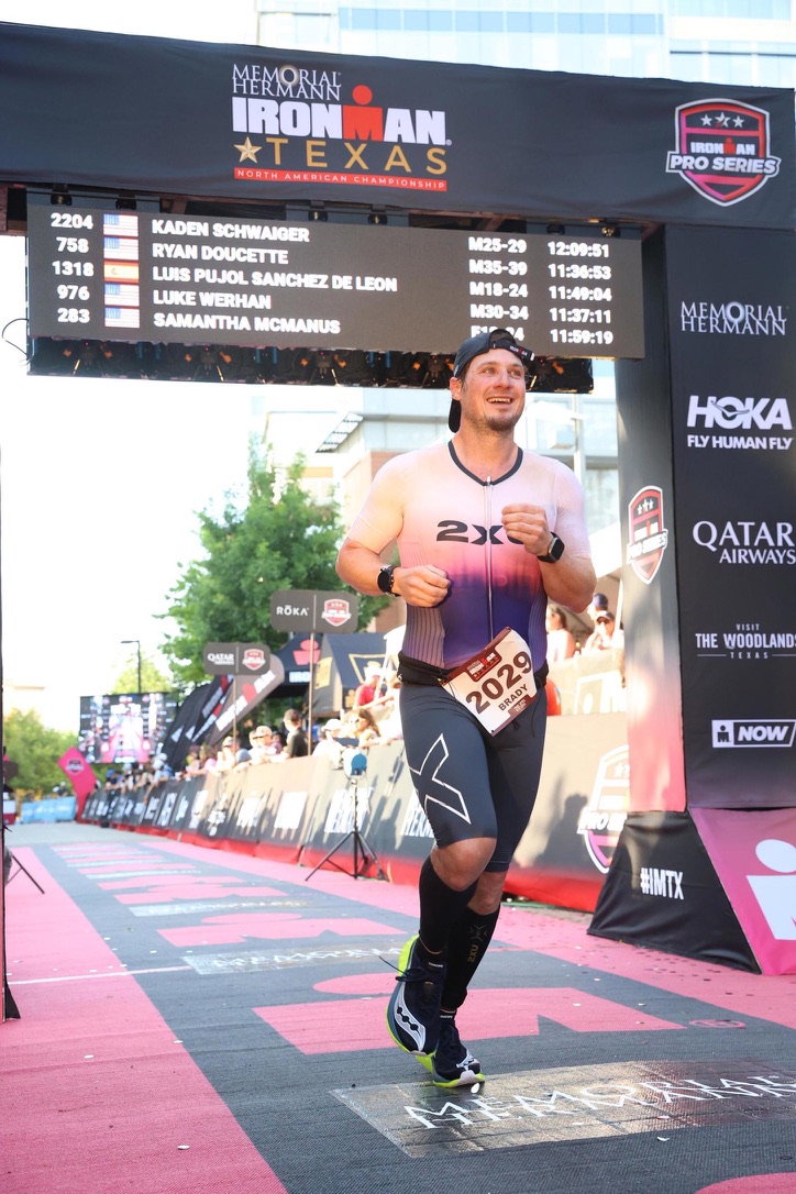 Brady crossing the finish line at Ironman Texas
